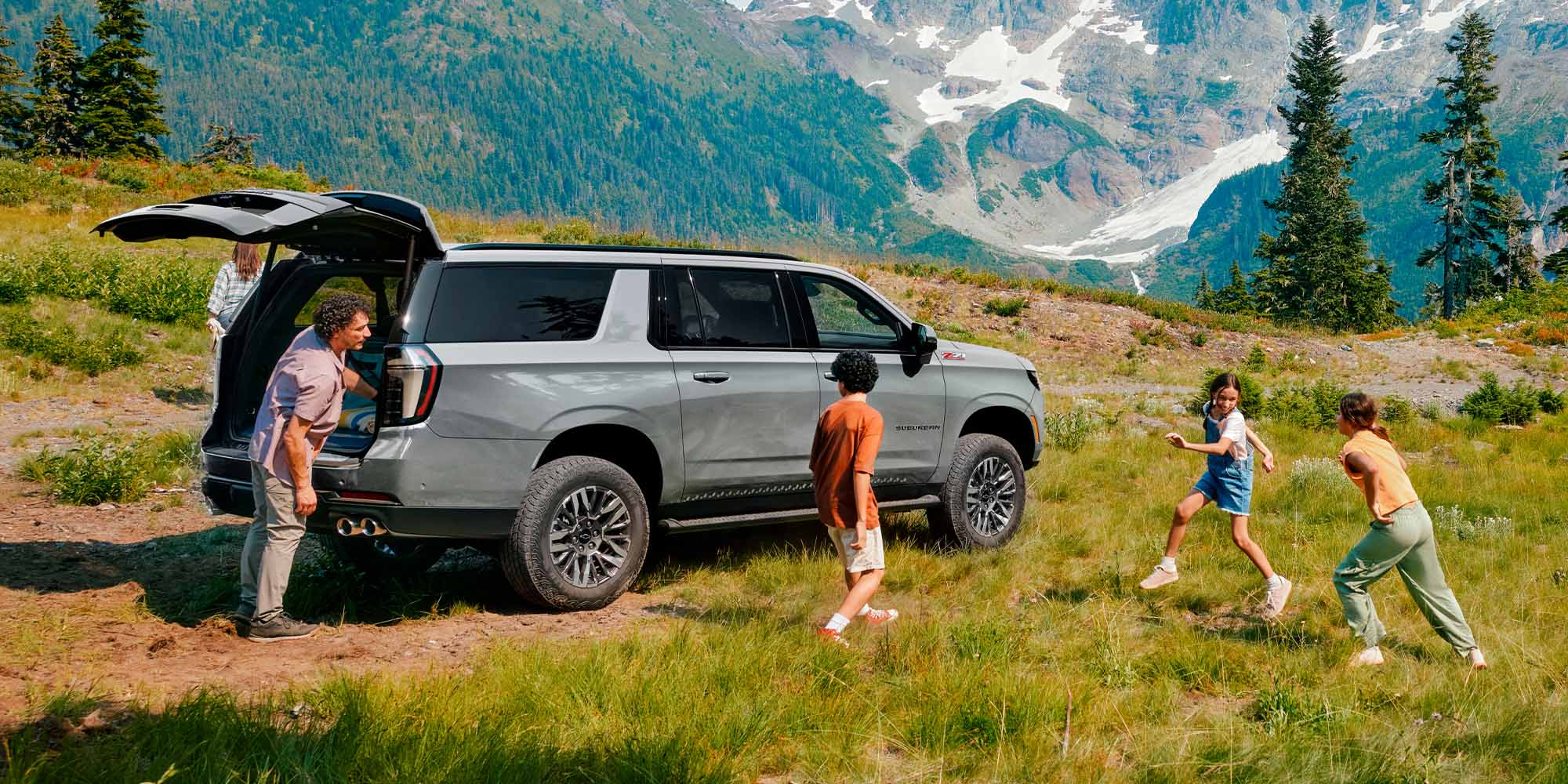 Chevrolet Suburban Z71 con una familia disfrutando de un paisaje montañoso.